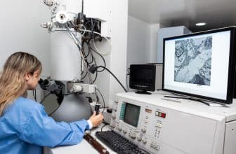 junge Frau am Elektronenmikroskop